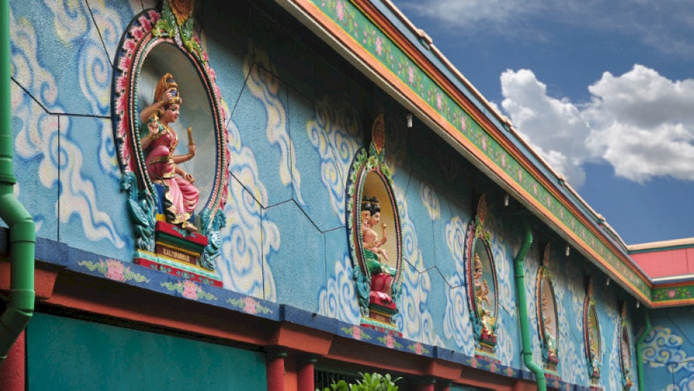 Statues of Hindu gods are around the temple grounds, showcasing intricate carvings and rich cultural symbolism
